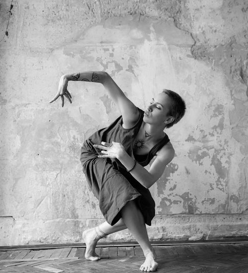 Woman in a dynamic and fluid motion pose against a light background.